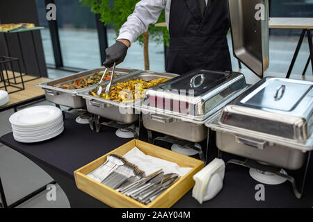 banquet table with chafing dish heaters. Many buffet heated trays at the catering Stock Photo