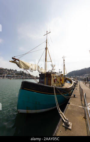 An old fishing boat tied alongside on the river dart in dartmouth. Stock Photo