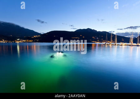 Lights of divers under water in Lake Caldonazzo. Trento province, Trentino Alto-Adige, Italy, Europe. Stock Photo