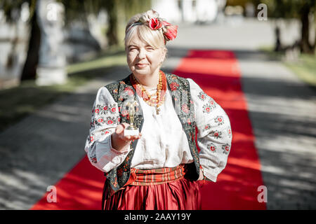 Portrait of a woman dressed in Ukrainian national dress as a well-known actress on the red carpet during awards ceremon Stock Photo