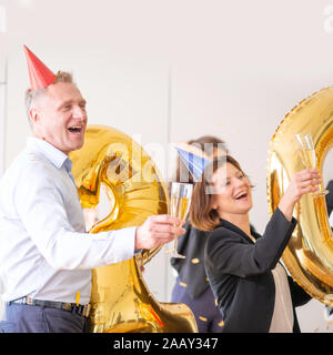 Business people are celebrating holiday in modern office drinking champagne and having fun in coworking. Merry Christmas and Happy New Year 2020 conce Stock Photo
