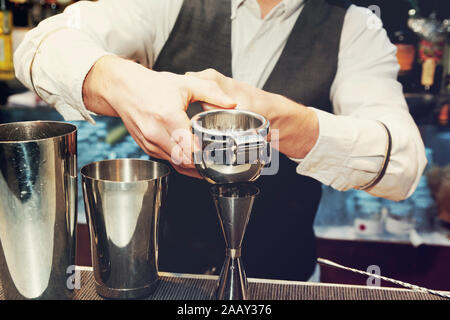 Bartender is squeezing citrus juice in jigger, toned image Stock Photo