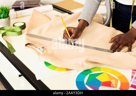 Unrecognizable Tailor Girl Working In Designer's Showroom, Cropped Stock Photo