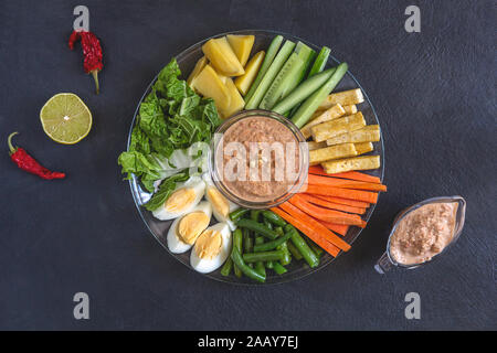 A traditional Indonesian gado-gado dish. Salad of boiled and fresh vegetables, eggs and tofu with peanut sauce. Stock Photo