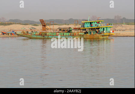 Working boat, in golden evening light, on the banks of the Irrawaddy river, Mandalay, Burma. Copy space for text Stock Photo