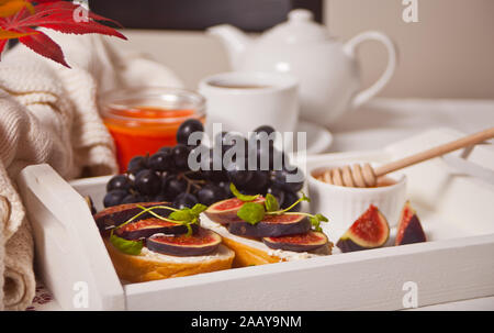 Sandwiches with cream cheese, figs and honey on the white tray. Healthy breakfast food concept. Stock Photo