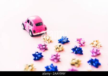 Small toy kids car and multi colored bows for gift wrapping Stock Photo