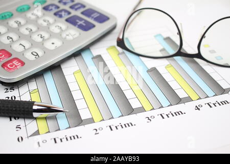 Elements on the desk, the study with a chart sheet divided into quarters. Stock Photo