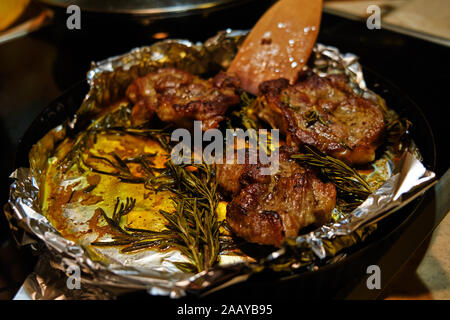 Roasted meat with rosemary on a foil 2019 Stock Photo