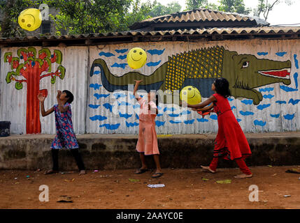 Pingla, West Bengal, India. 23rd Nov, 2019. Village kids play with balloons beside a decorated Wall.Naya Village under Pingla Block is a small village under Paschim Midnapore District of West Bengal, India which is famous for their colourful Ancient Folk Art. Almost 60 Families of this village are associated with the Art Patachitra, an ancient folk art of Bengal, the art is appreciated by art lovers all over the world for its style of drawings, shape, pattern, textures and colours. The Art is based on mythological tales and tribal rituals to stories based on modern Indian history and conte Stock Photo