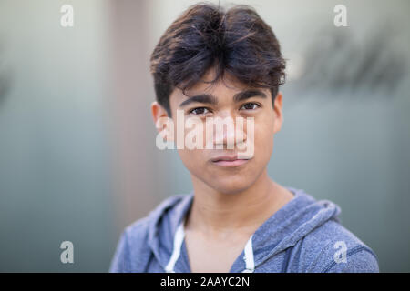 Portrait of a handsome cocky young man next to the blurred background Stock Photo