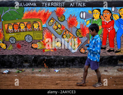 Pingla, West Bengal, India. 23rd Nov, 2019. Village kid walks past a decorated wall.Naya Village under Pingla Block is a small village under Paschim Midnapore District of West Bengal, India which is famous for their colourful Ancient Folk Art. Almost 60 Families of this village are associated with the Art Patachitra, an ancient folk art of Bengal, the art is appreciated by art lovers all over the world for its style of drawings, shape, pattern, textures and colours. The Art is based on mythological tales and tribal rituals to stories based on modern Indian history and contemporary issues h Stock Photo