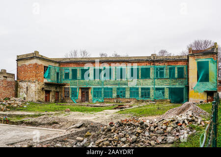 reconstruction of an old two-story brick house, facade covered with green safety net Stock Photo