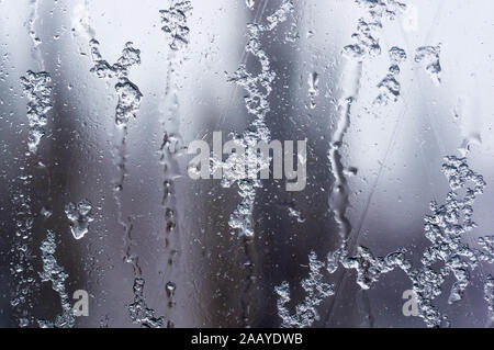 glass in the window covered with wet melting snow, close-up, macro Stock Photo