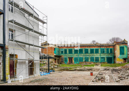 reconstruction of an old two-story brick house, facade covered with green safety net Stock Photo