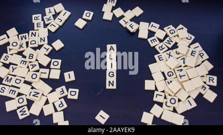 Align tile letters on a black background with mixed letters on either side Wide angle. Concept for business, personal or other goal-setting initiative Stock Photo
