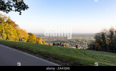 View of people enjoying and looking at the view of an autumn sunset from the top of Box Hill in Surrey Stock Photo