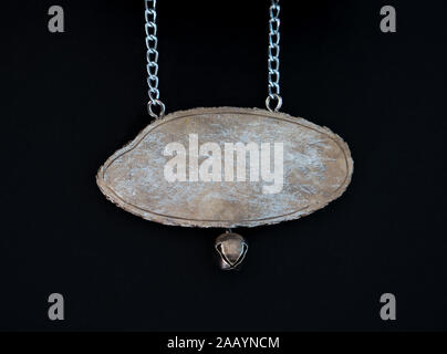 close up of a wooden sign plate with metal chain on black background Stock Photo