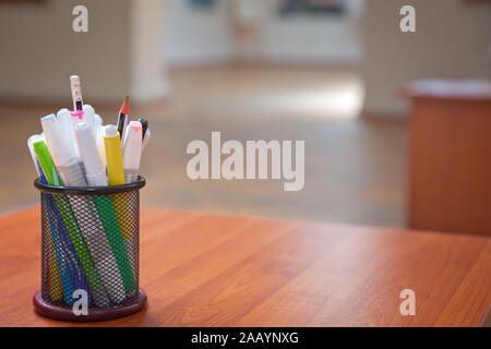 Box for pens and pencils . Colored pencils in a pencil case on the wooden table . Color pencils in black case . Close-Up color pencils and markers in Stock Photo
