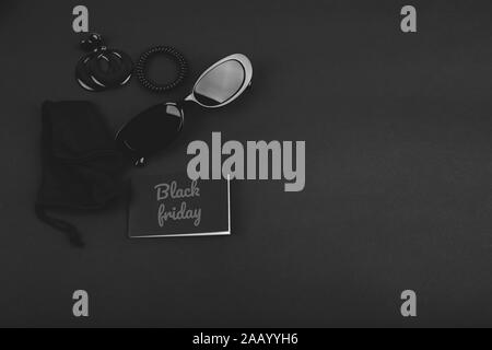 Black monochromatic flatlay on black background. Accessories and beauty equipment. Black friday sale concept. Space for text Stock Photo