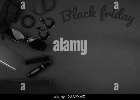 Black monochromatic flatlay on black background. Accessories and beauty equipment. Black friday sale concept. Space for text Stock Photo