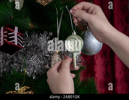 Hands decorating Christmas tree, photo-illustration Stock Photo
