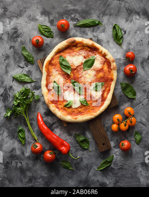 Flatlay of vegetarian rustic pizza Margherita with raw ingredients on dark background copyspace Stock Photo