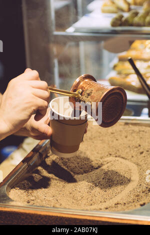 Brewing Turkish coffee on hot sand. The traditional method of making coffee in Turkey and the Middle East. Stock Photo