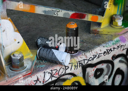 Empty spray paint cans discarded by graffiti artists Stock Photo