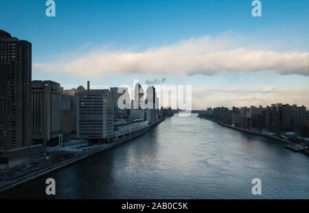 Scenic of East river and buildings from Queensboro bridge cablecar. Blue sky and a few clouds visible. Stock Photo