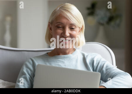 Elderly woman chatting online with friend using computer Stock Photo