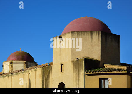 Historic towers with red round domes in the old town of Mazara del Vallo, Sicily, Italy against a blue sky in summer Stock Photo