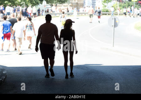 Different body types. Silhouette of a young couple walking hand by hand. Stock Photo