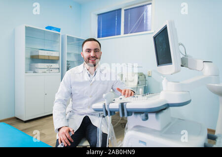 handsome doctor using an ultrasound machine Stock Photo