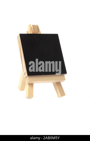 Miniature blackboard on a wooden stand isolated on white background. Stock Photo