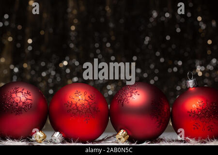 Christmas decorations composition view of four red evening balls with red glitter snowflakes on it on dark background with silver and gold colors boke Stock Photo