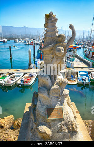 'Boy on a Seashore' stone sculptor, a gift from Puerto Vallarta, MX, overlooks the boat filled marina at the Santa Barbara Harbor in Santa Barbara, CA Stock Photo