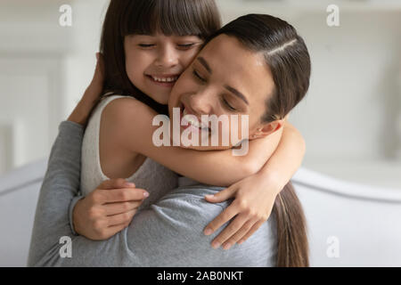 Mother cuddle daughter feeling love and connection closeup view Stock Photo