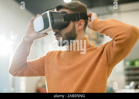 Guy looking through VR (Virtual Reality) glasses - Looking into the ...