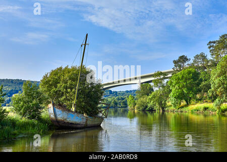 Image of the vilaine riverfrom the Northern approach to Redon with a wrecked boat and the D164 bridge. Stock Photo