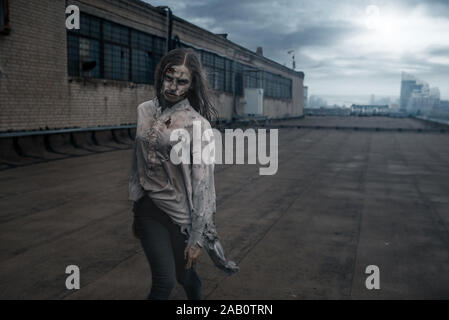 Female zombie on the roof of abandoned building Stock Photo