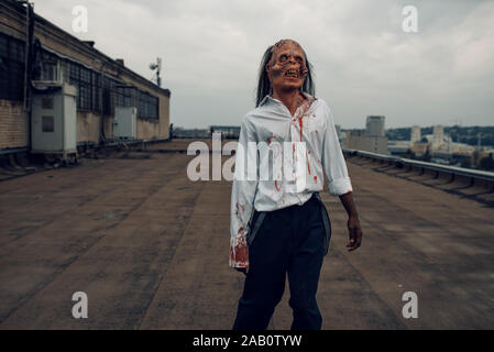 Scary zombie on the roof of abandoned building Stock Photo