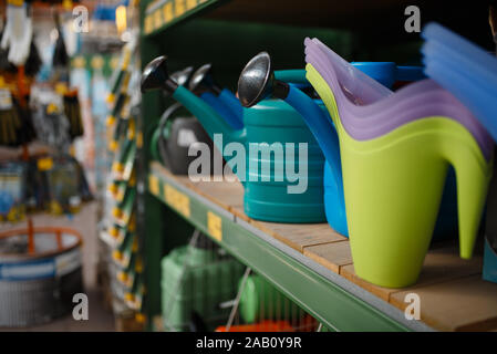 Watering cans on the shelf, shop for floristry Stock Photo