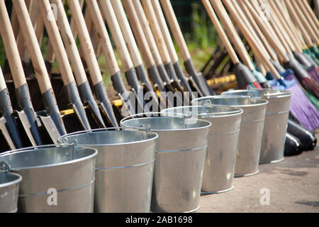 Gardener's tools on the street. Many tools for planting trees. Shovels and buckets are in a row. Tools for landscaping. Hardware. Agricultural items. Stock Photo