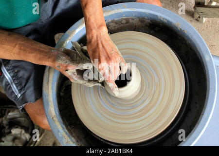 closeup of hands making pottery on pottery wheel Stock Photo