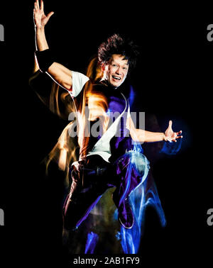 one chinese young man hip hop break dancer dancing isolated on black background with speed light painting effect motion blur Stock Photo