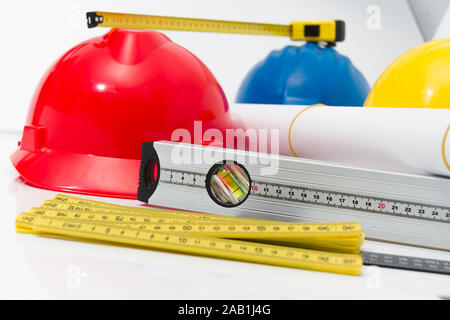 Photo of theColorful helmets and tools for construction drawings and buildings Stock Photo