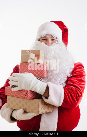 Joyful smiling Santa Claus with hands full of presents for christmas Stock Photo