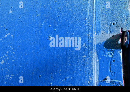 Old door blue color close-up lit by the bright sun. Abstract background Stock Photo