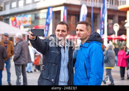 Portrait of the handsome twin guys in the city taking selfie withe the mobile phone Stock Photo